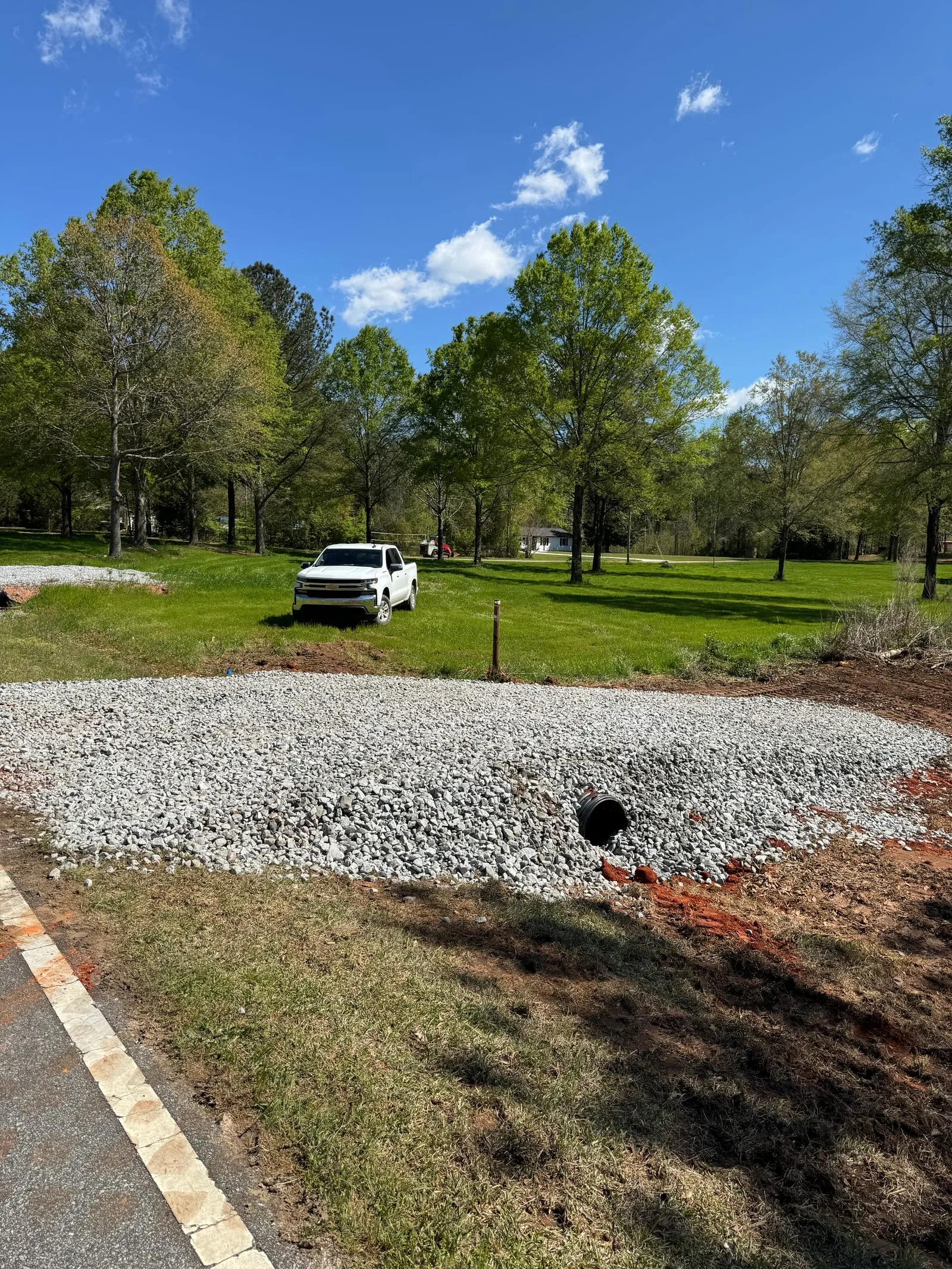 New gravel driveway entrance built over a drainage culvert pipe.